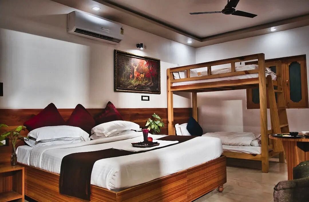 Spacious lounge area with comfortable sofas and large windows overlooking Rishikesh.